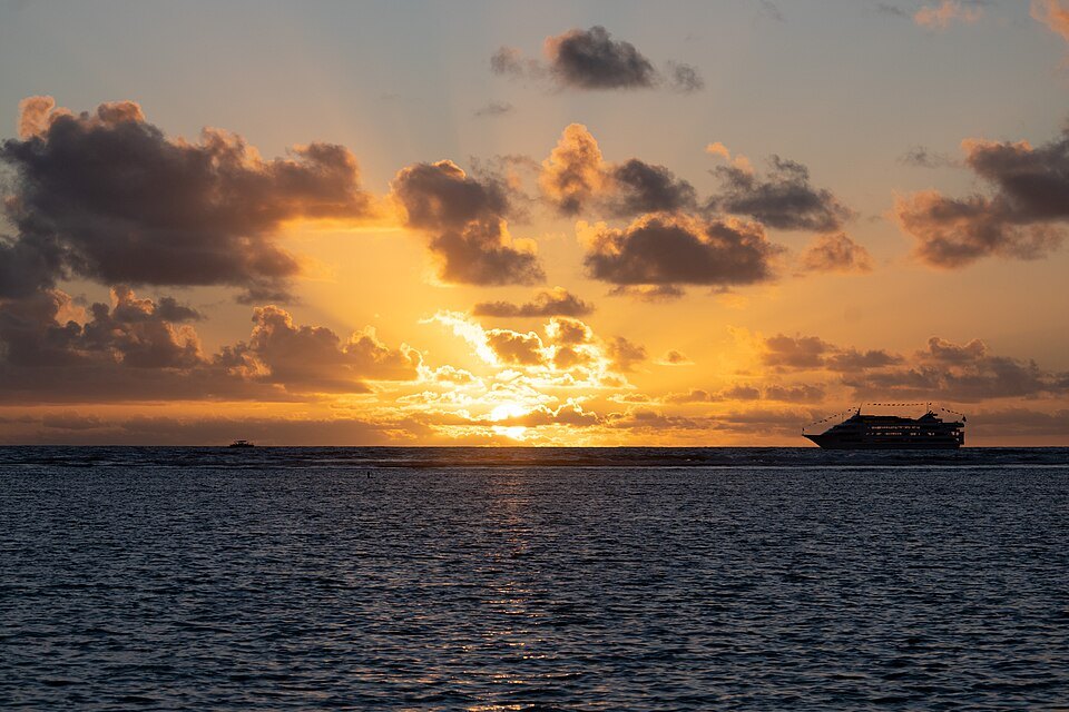Sunset over the Pacific from Ala Moana, a boat heading out