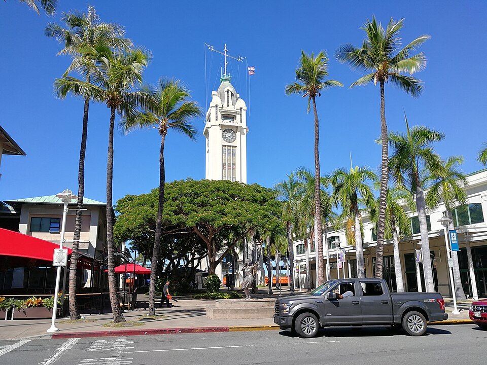 Aloha Tower between the palms of the marketplace forecourt