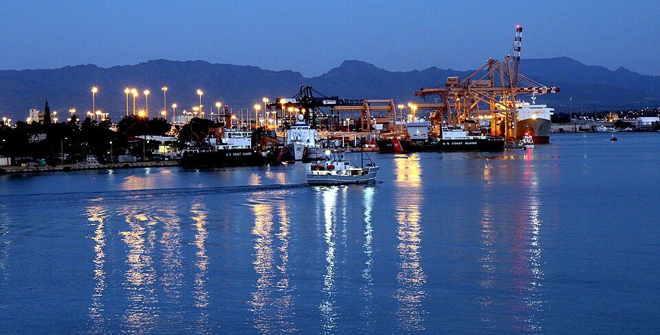 Honolulu Harbor at dawn, its lights reflected in the water