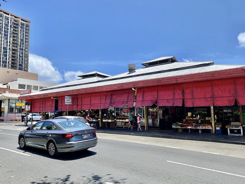 Oʻahu Market's open stalls on King Street, under red awnings