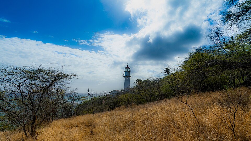 Dry grass on the seaward slope, the lighthouse below