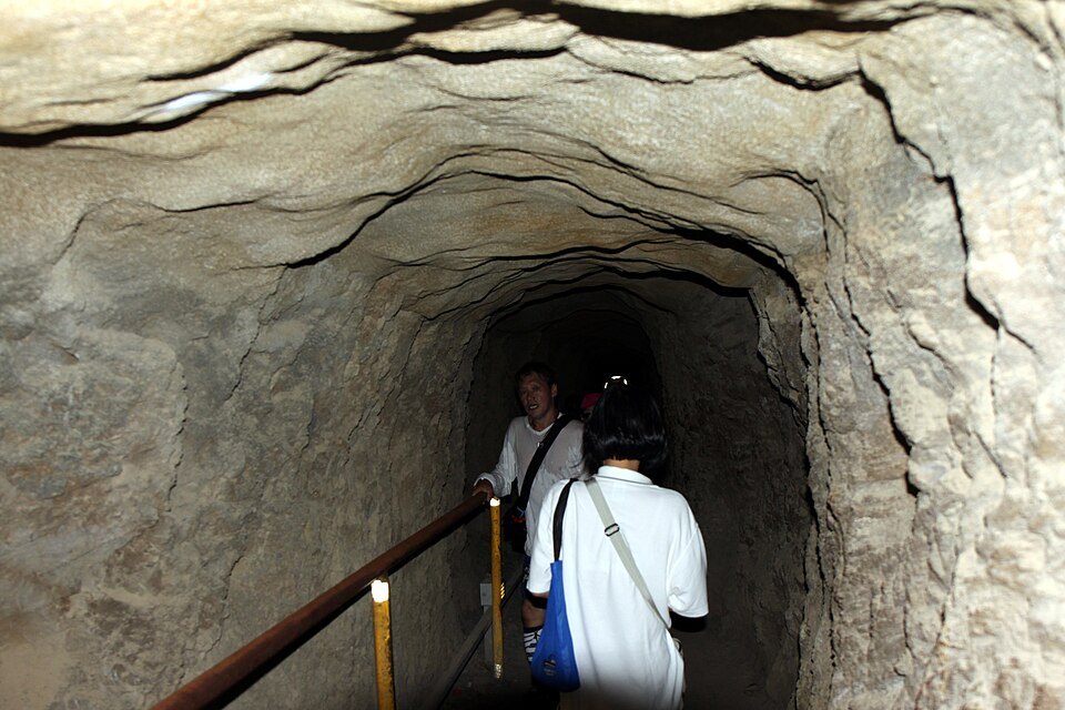 Walkers in the narrow rock tunnel near the top of Diamond Head