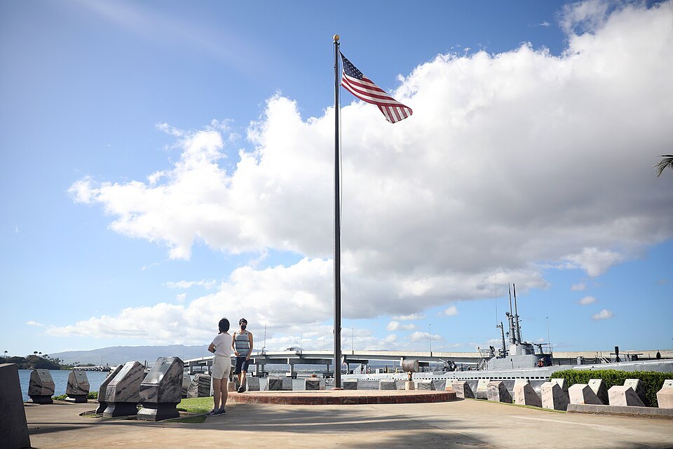 The flagpole and memorial stones on the shore at Pearl Harbor
