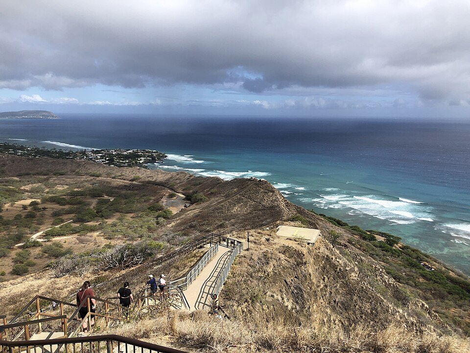 Walkers on the summit stairs of Diamond Head, the coast below