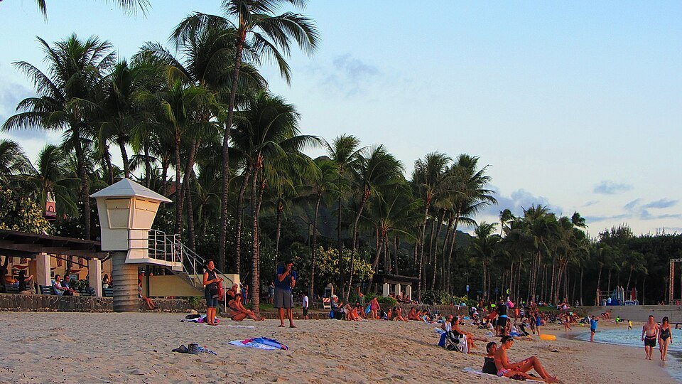 Late afternoon on Waikīkī Beach, a lifeguard tower among the palms