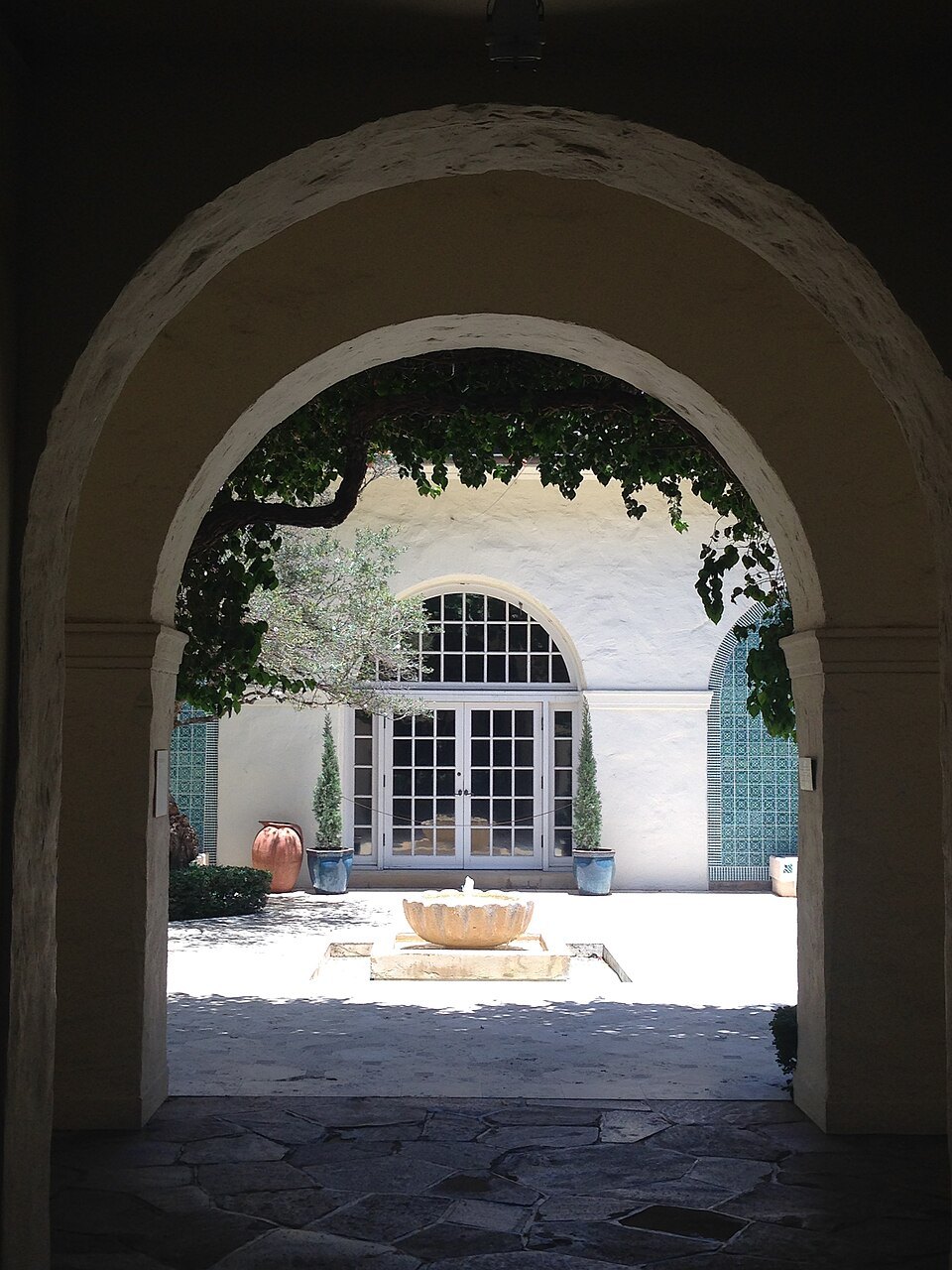 Through an archway into a courtyard with its fountain