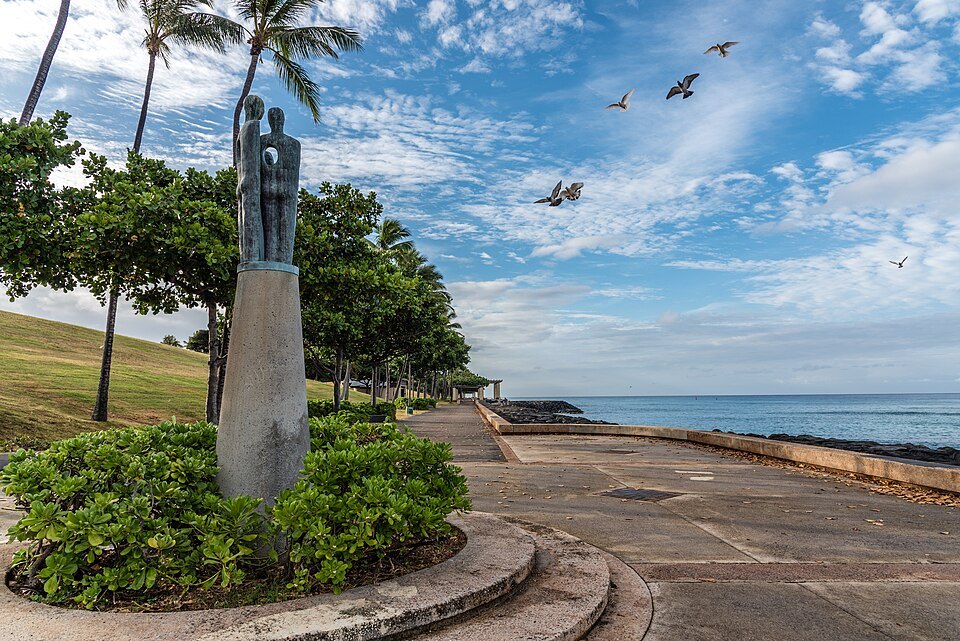 A sculpture of two figures above the shore path at Kakaʻako Waterfront Park